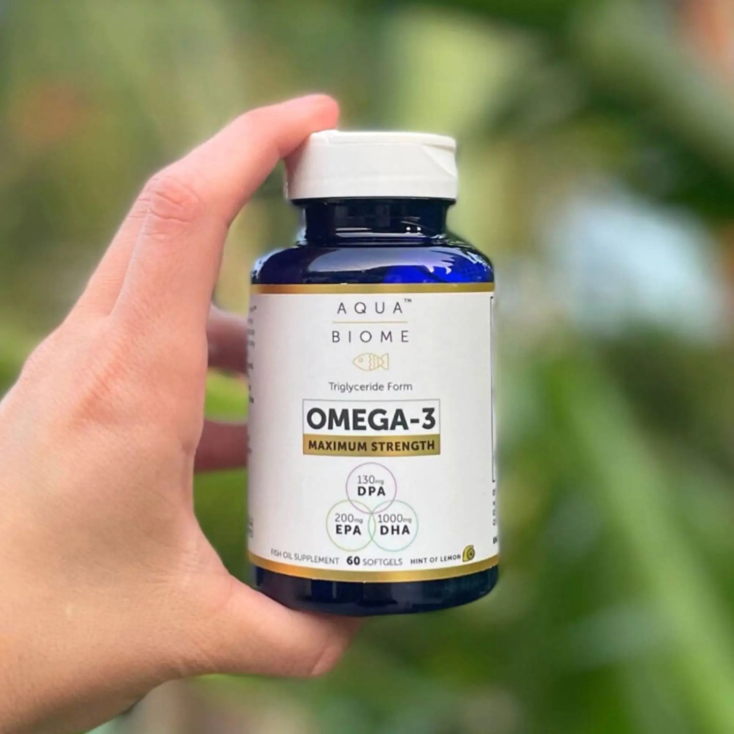 person holding a bottle of aquabiome fish oil ma strength