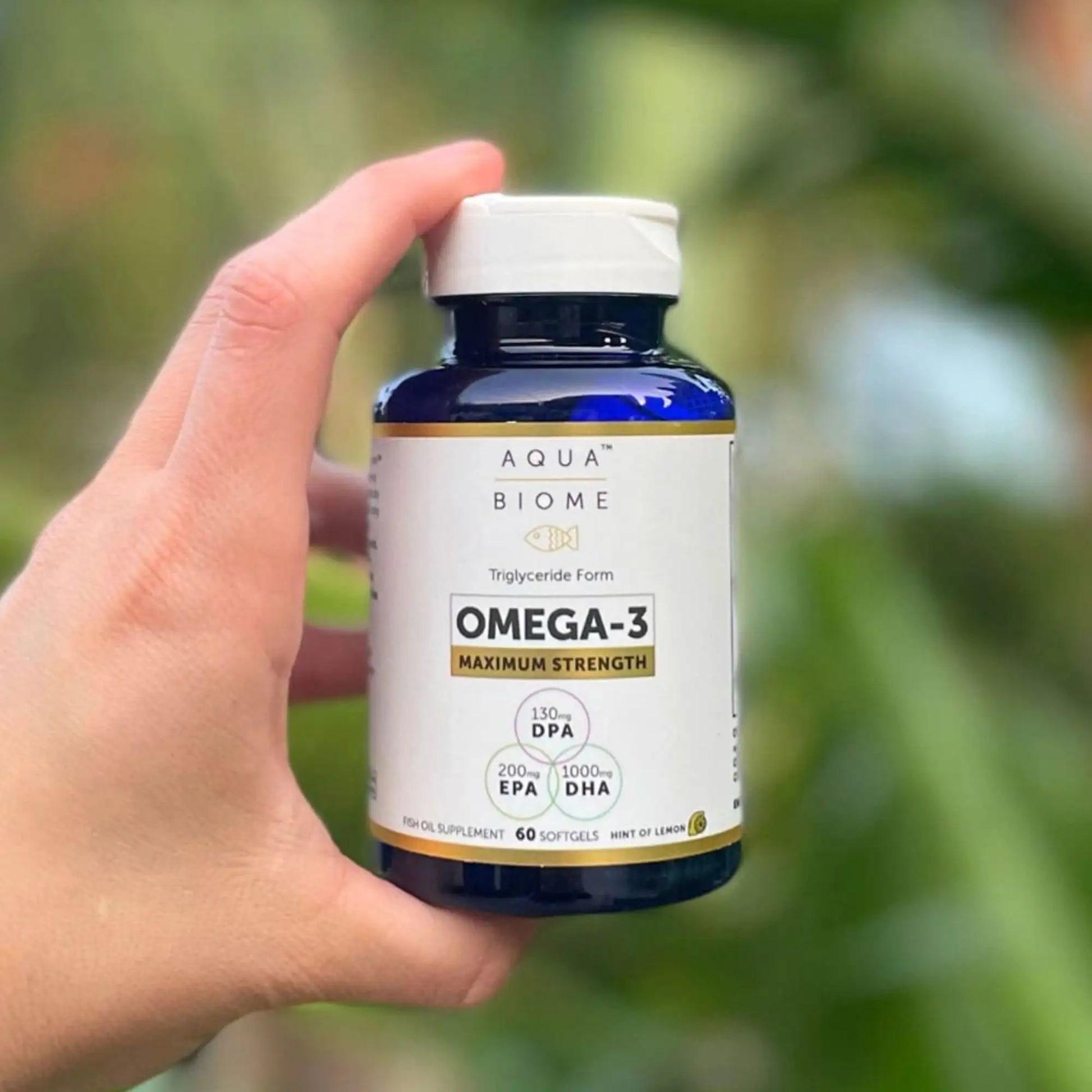 person holding a bottle of aquabiome fish oil ma strength