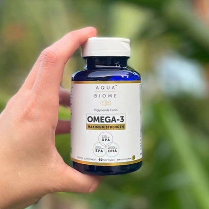 person holding a bottle of aquabiome fish oil ma strength