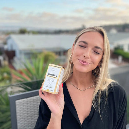 person holding aqua biome carton and smiling for a photo